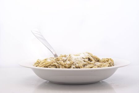 Spaghetti with pesto and cheese isolated on white backgroundの写真素材