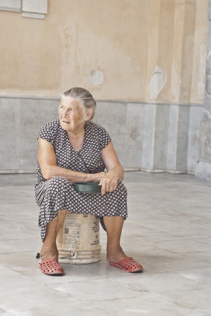 PALERMO - JUNE 2012- A homeless old woman beggar sitting near Palermo cathedral and asking for help on July 28, 2012 in PALERMO, Italy.のeditorial素材