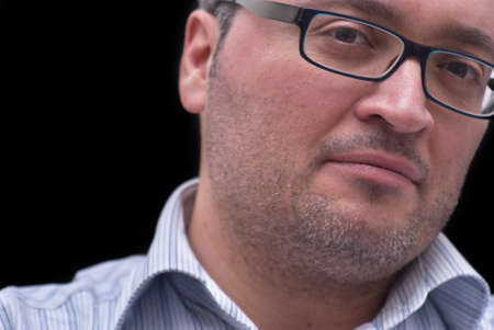 Close up portrait of man with glasses on black backgroundの写真素材