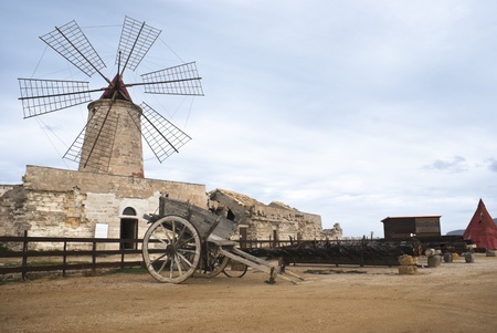 old windmill in sicily with old sicilian cart, trapani, italyの写真素材