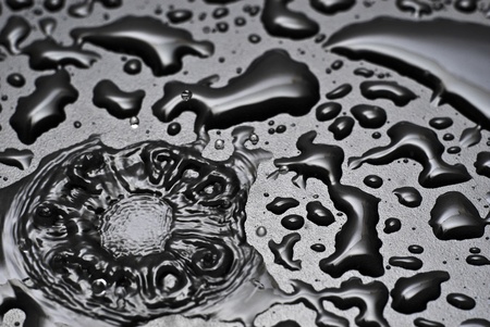 A water drop splashes into a pool of waterの写真素材