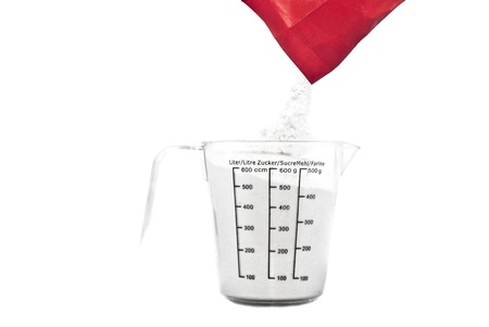  Pouring flour on Kitchen measuring cup. isolated on whiteの写真素材