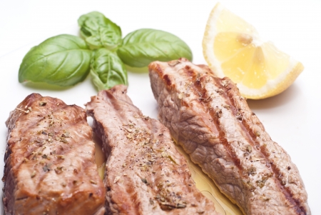 Grilled beef sliced with basil and lemonsの写真素材