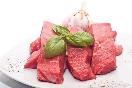 Raw beef on white background with basil and garlicの写真素材
