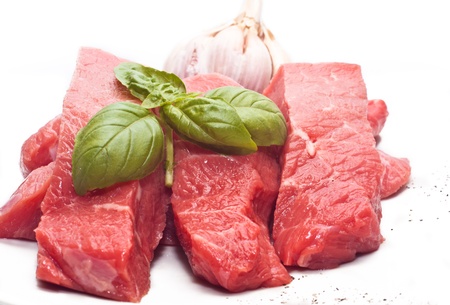 Raw beef on white background with basil and garlicの写真素材