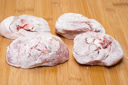 ossobuco floury (bone-in lamb shank steaks) on a wooden chopping boardの写真素材