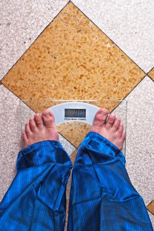 A scale with two feet of the person standing on itの写真素材