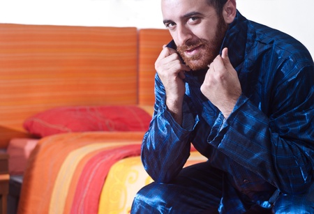 Man sitting on bed in pajamasの写真素材