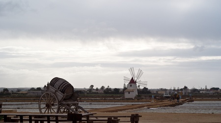 Old windmill on the salines near trapani with lake and bridgeの写真素材