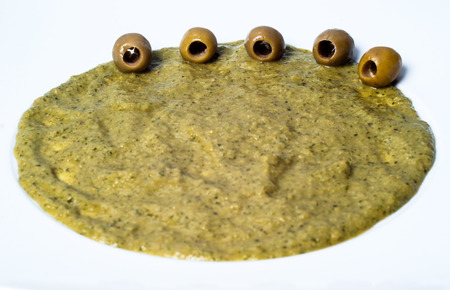 spicy pate of olives in white dishの写真素材