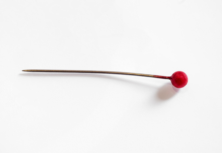 One old sewing push pin isolated on white background