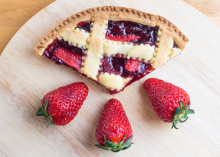 slice of fresh homemade cherries tart and  strawberry on wooden table.closeupの写真素材