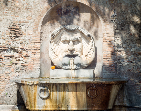 Beautiful fountain in orange gardens in Rome, Italy. Is this wonderful fountain of a giant, grotesque mask, which spits water into a giant, ancient Roman basinの写真素材