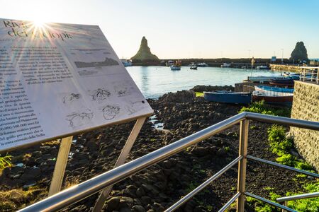 Riviera dei Ciclopi. Acitrezza harbor with old boat and lachea island in Sicily, Italyの写真素材