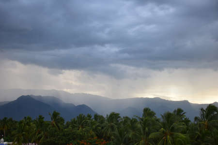 Rain shower falling from dark cumulus clouds