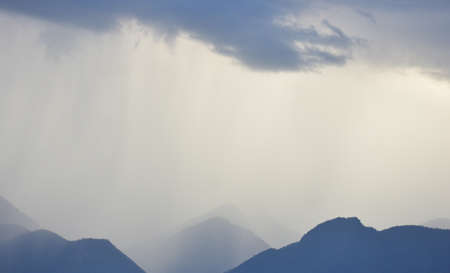 Rain shower falling from dark cumulus clouds