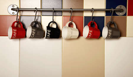Colorful coffee cups on hooksの写真素材