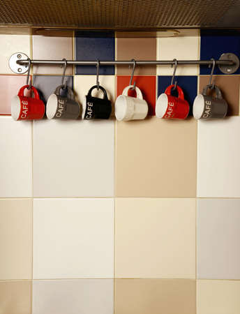Colorful coffee cups on hooksの写真素材