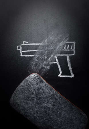 weapon draw erased on blackboard - no violence conceptの写真素材