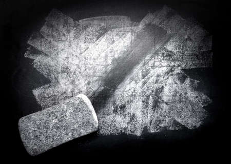 piece of chalk and eraser on blackboardの写真素材