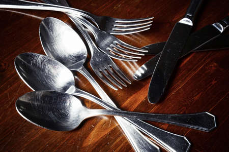 old used cutlery  on dark wooden tableの写真素材