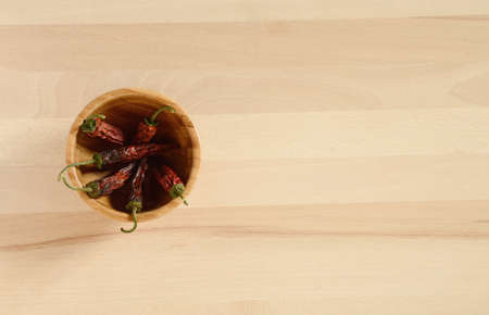 dried chili peppers in a wooden bowlの写真素材