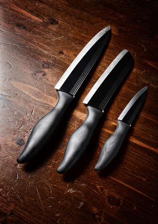 sharp knives  on dark wooden tableの写真素材