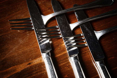 old used cutlery  on dark wooden tableの写真素材