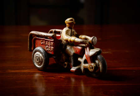red vintage toy tricycle on dark wooden tableの写真素材