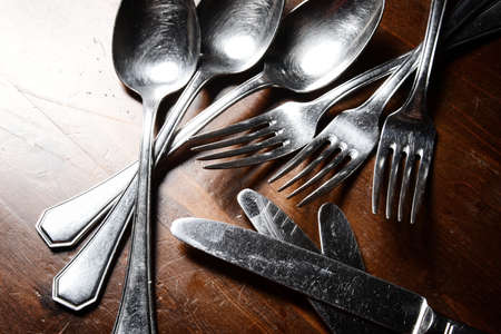 old used cutlery  on dark wooden tableの写真素材
