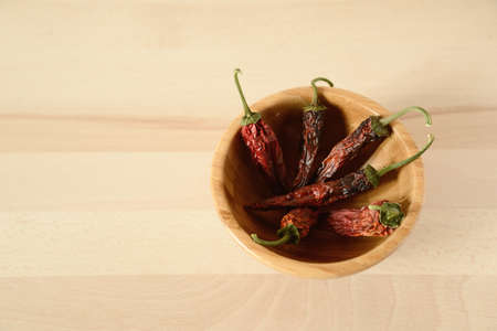 dried chili peppers in a wooden bowlの写真素材