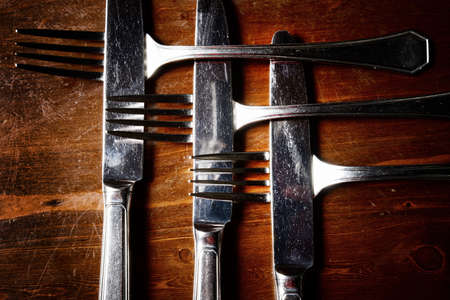 old used cutlery  on dark wooden tableの写真素材