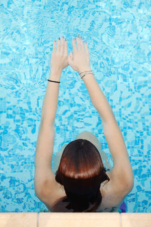 beautiful young woman relaxing in water by the swimming pool