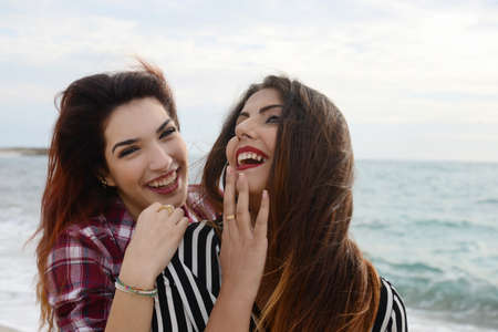 gossip girls smiling on the beachの写真素材