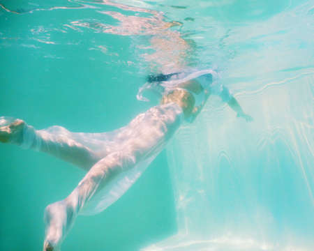 woman beautiful body swim underwater in white dressの写真素材