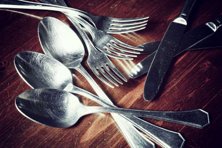 vintage  used cutlery  on dark wooden tableの写真素材