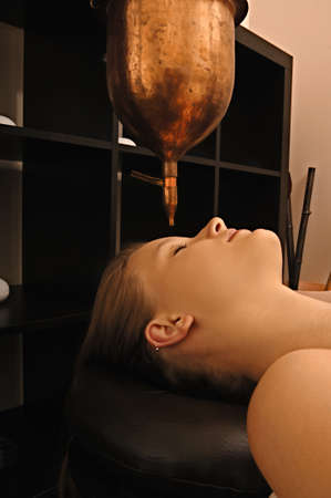 young woman receives body treatment in spa salonの写真素材