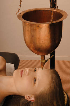 young woman receives body treatment in spa salonの写真素材