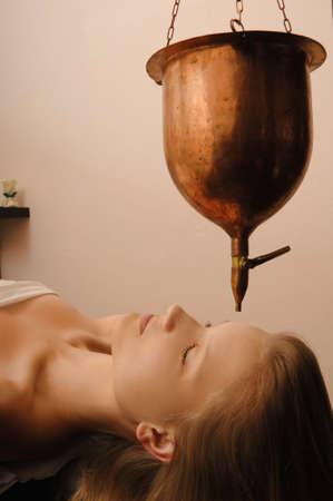 young woman receives body treatment in spa salonの写真素材