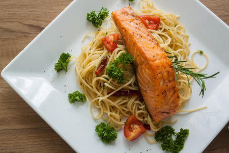 Spaghetti with salmon fillet on white dish , top viewの写真素材