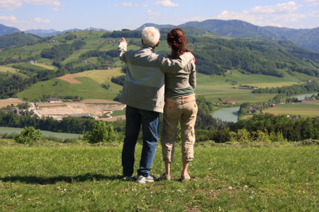 Senior couple standing on a hill and looking at the landscape in the backgroundの写真素材