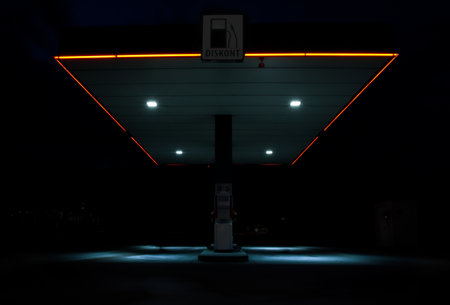 night scene of a gas station with neon lights and empty space for textの写真素材