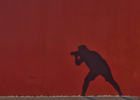 silhouette of a photographer on a background of a red wallの写真素材