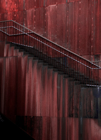 Staircase with railings on a red wall in the city