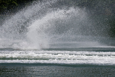 Water splashes from the wake of a boat on the lake.の写真素材