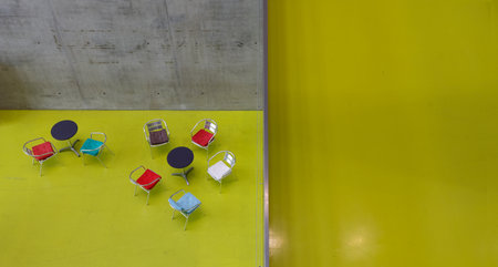 Interior of a modern office building with yellow and black chairs.