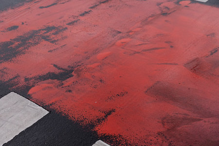 Red paint on the asphalt road. Abstract background and texture for design.の写真素材