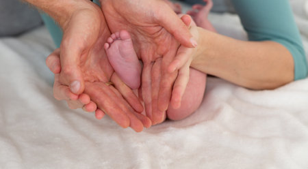 Close-up of newborn baby feet in mother's hands. Family concept.の写真素材