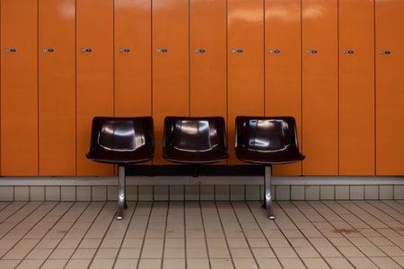 Row of chairs in an orange locker room, waiting for a trainの写真素材