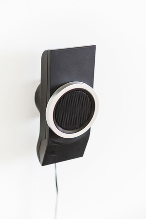 Speaker mounted on a white wall. Part of the home theater 5 to 1.